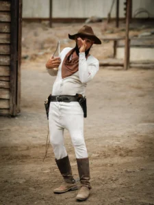 Cowboy valkoisessa asussa pölyisellä kadulla