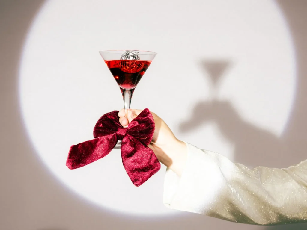 Käsi nostaa cocktaillasin valokeilassa