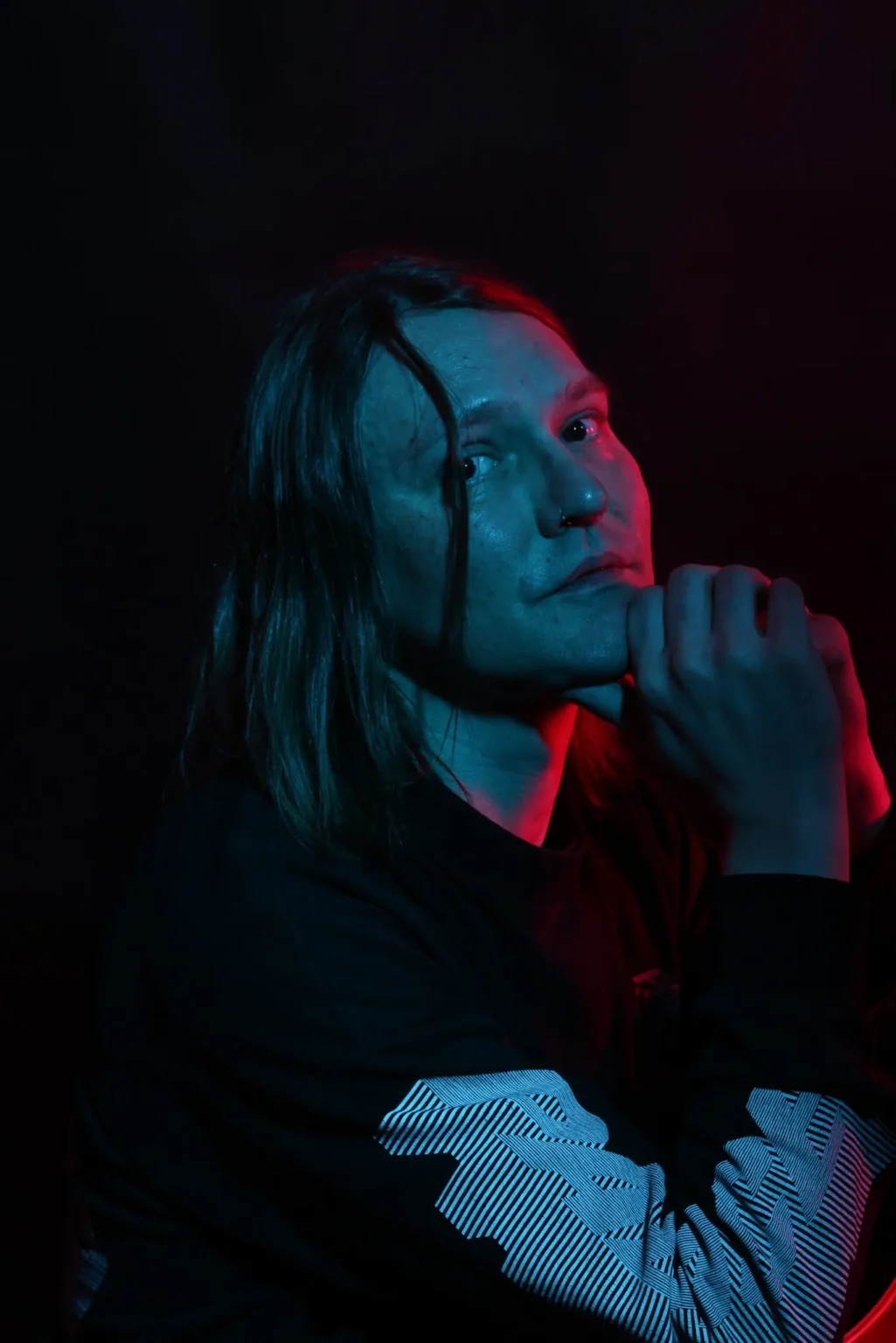Luova studiopotretti miehestä punasinisessä valossa
